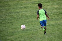 a boy running after a soccer ball 