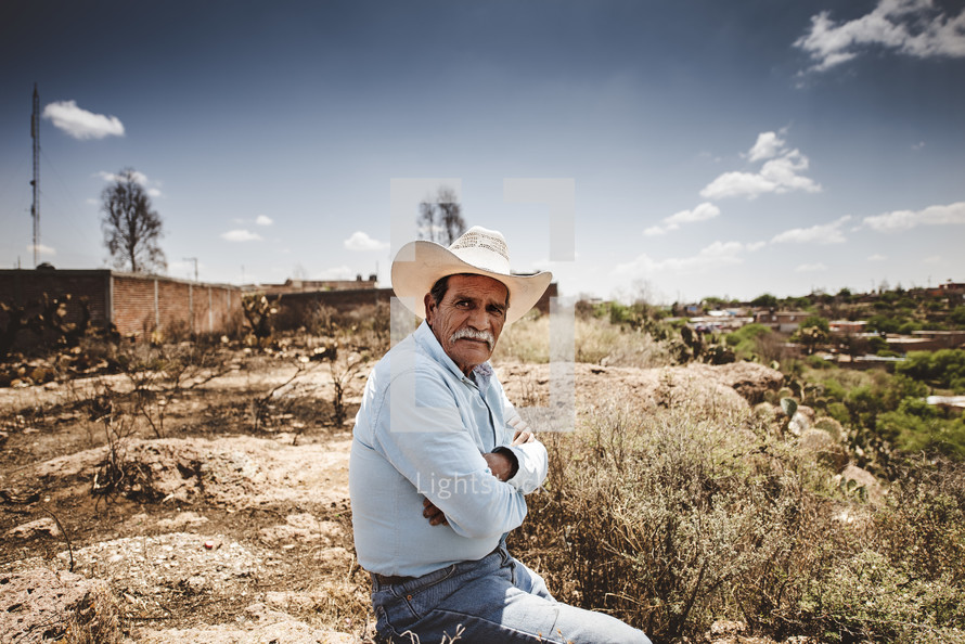 rancher sitting in a desert landscape 
