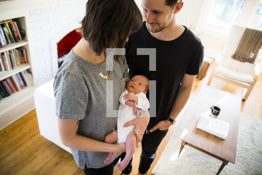 new parents holding their newborn 