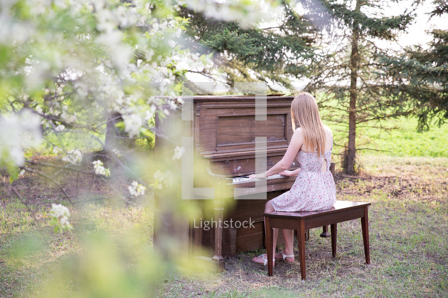 a woman playing a piano outdoors 