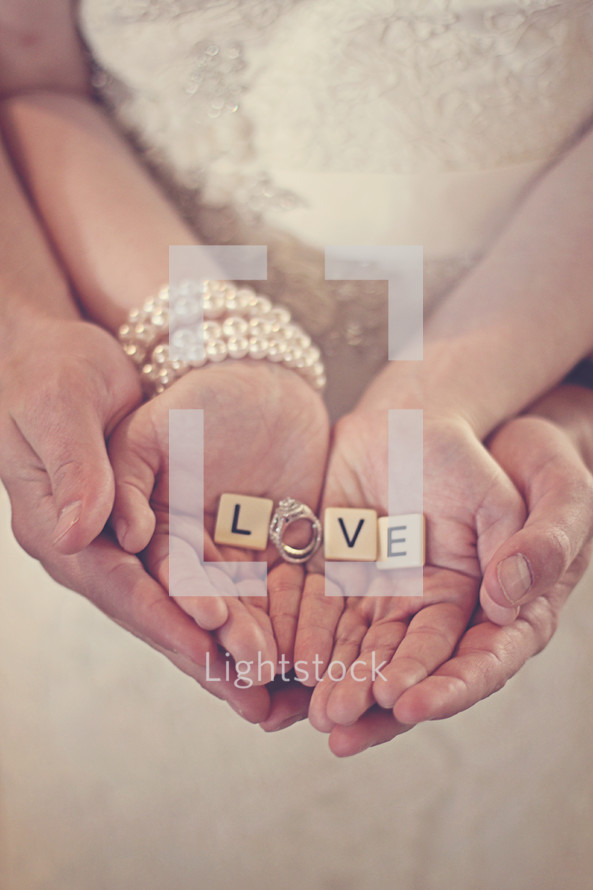 couple holding the word love in their hands 