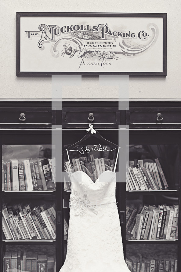 wedding dress hanging on a bookcase