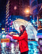 a woman standing in the rain holding an umbrella 