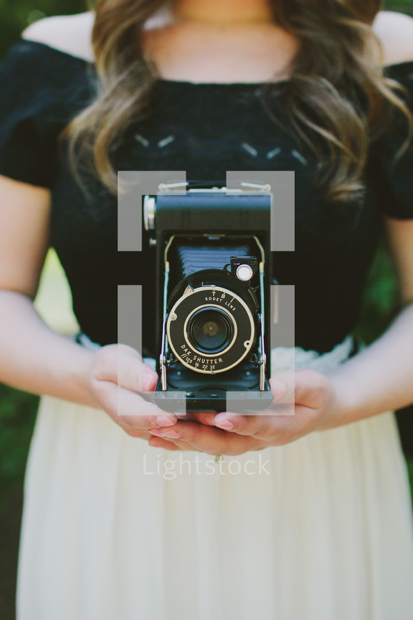 Woman holding a vintage camera.