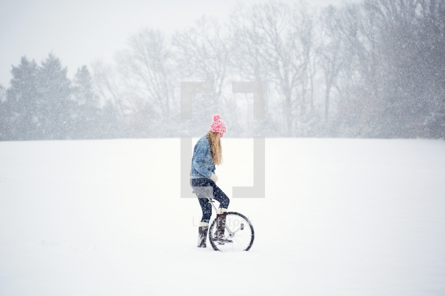 a woman with a unicycle in the snow 