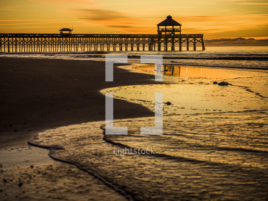 pier and tide at a beach at sunset 