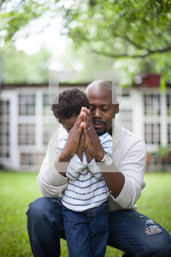 father and son with praying hands 