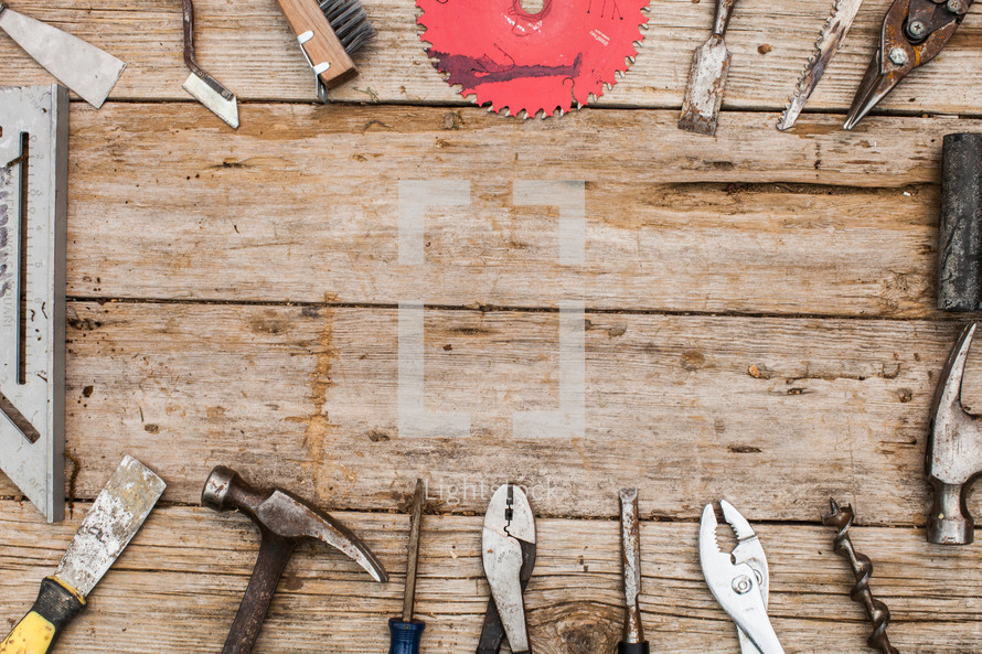 Tools in a circle on a rustic wooden table.