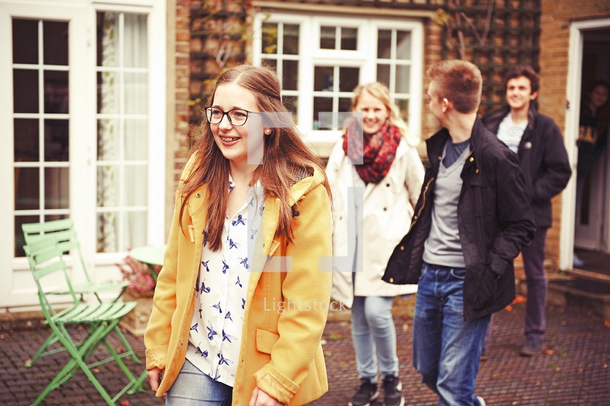 teens walking out a backdoor onto a courtyard 