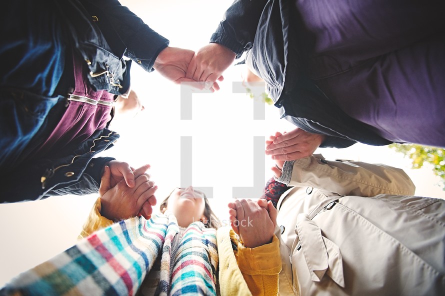 teens holding hands in a prayer circle 