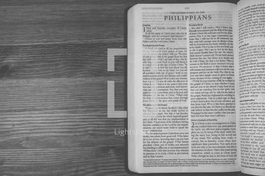 Bible on a wooden table open to the book of Philippians.