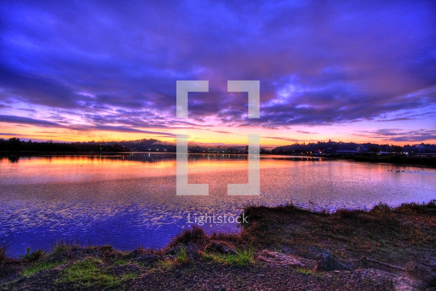purple clouds and sky during a sunset over a lake