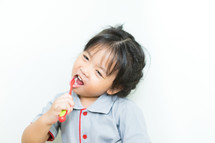 little girl in her pajamas brushing her teeth