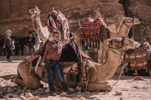 a child with a camel in the desert 
