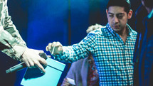 a man giving a cash donation during a worship service 