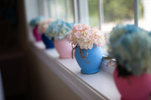 Vases of flowers in a window sill.