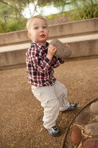 Boy holding a rock.