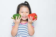 toddler girl holding peppers 