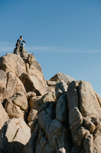 men sitting on a rock looking out at the desert 