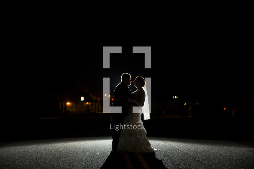 silhouette of a bride and groom in the spotlight 