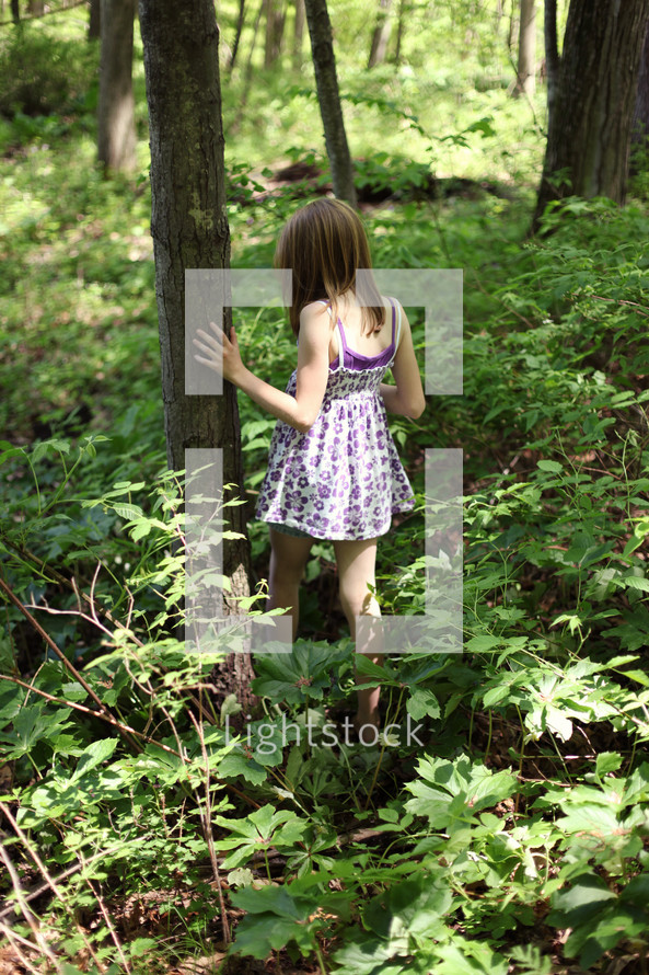 child walking through overgrowth in on a forest floor