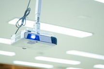projector hanging from a ceiling in a classroom 