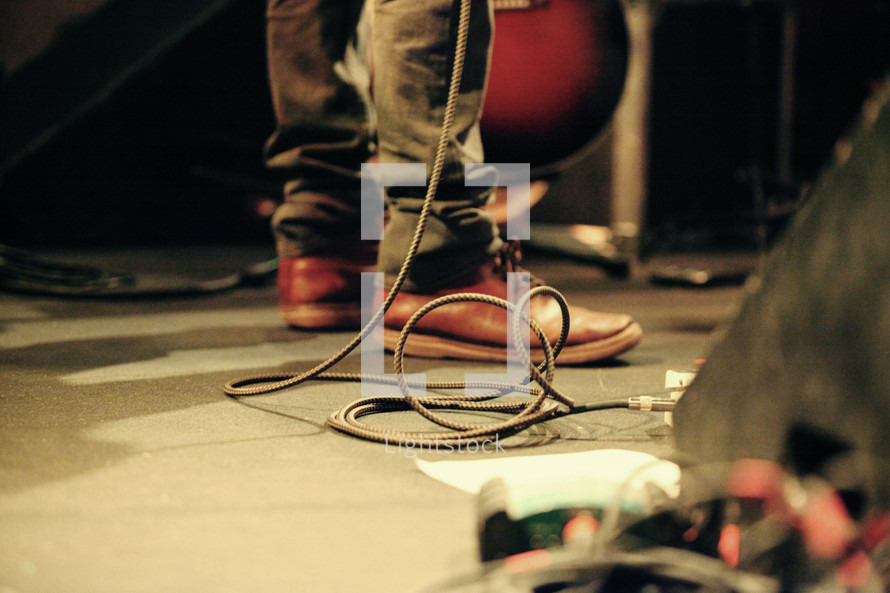 musician's feet among amp cords