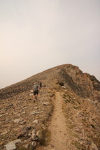 a man walking up a steep rocky slope 