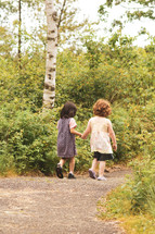 toddler girls walking holding hands 