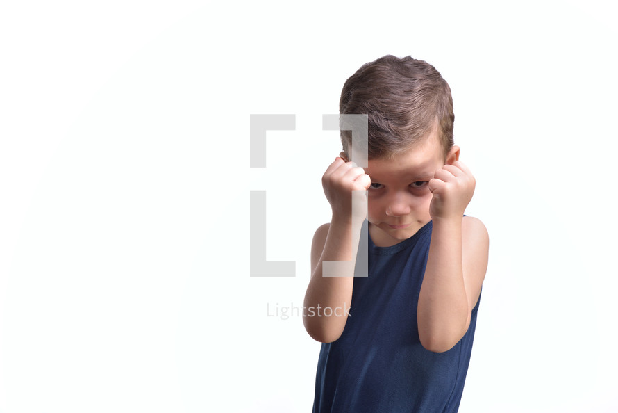 Little boy boxing, shows his fists, isolated on white