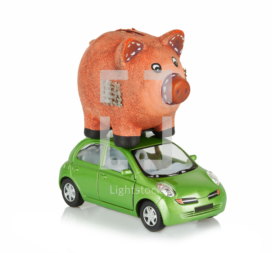 Small green car with an piggy bank on the roof.