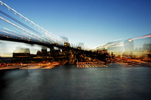 blurry image of a bridge over a river and city lights 
