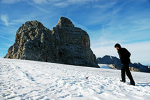 man walking up a snowy mountainside 