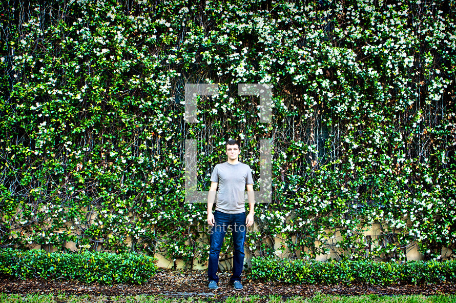 Man in front of wall made of wildflowers