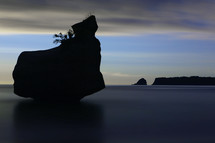 silhouette of a rock formation in the ocean 