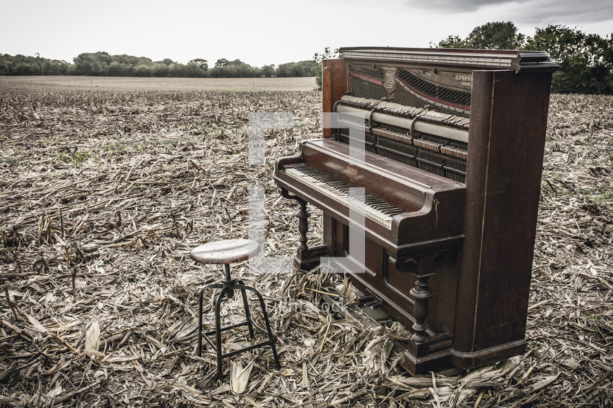 old piano in a plowed field 