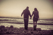 couple holding hands at a beach 