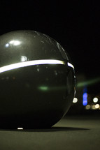 round sculpture at night 