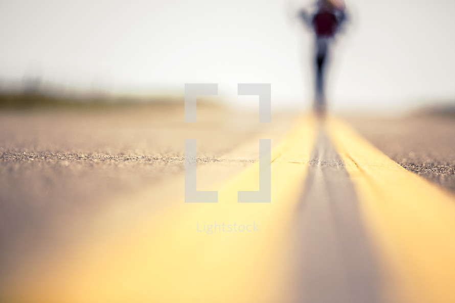 Woman walking down the middle of the road.