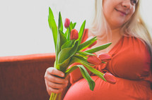 pregnant woman holding tulips 
