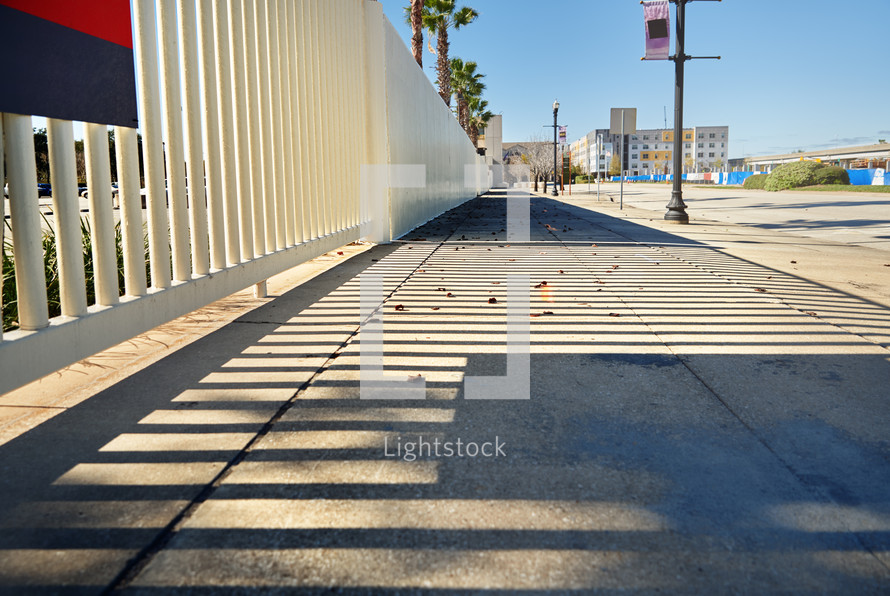 Sidewalk with fence shadows