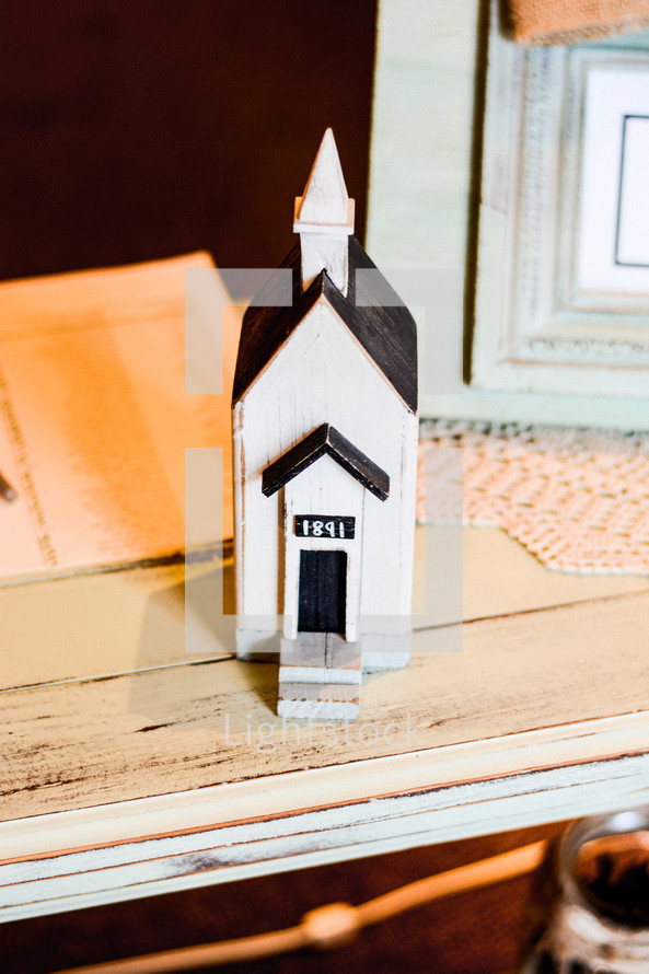 a small wooden church on a side table 
