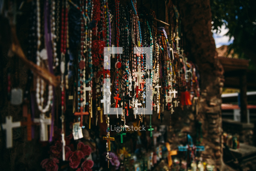 An outdoor booth with multicolored rosaries for sale.