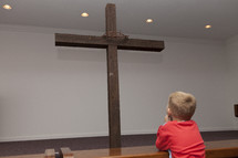 boy child looking at a cross 