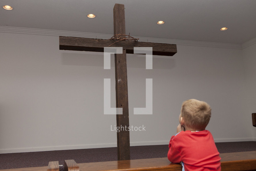 boy child looking at a cross 