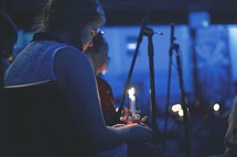 holding candles at a Christmas Eve worship Service 