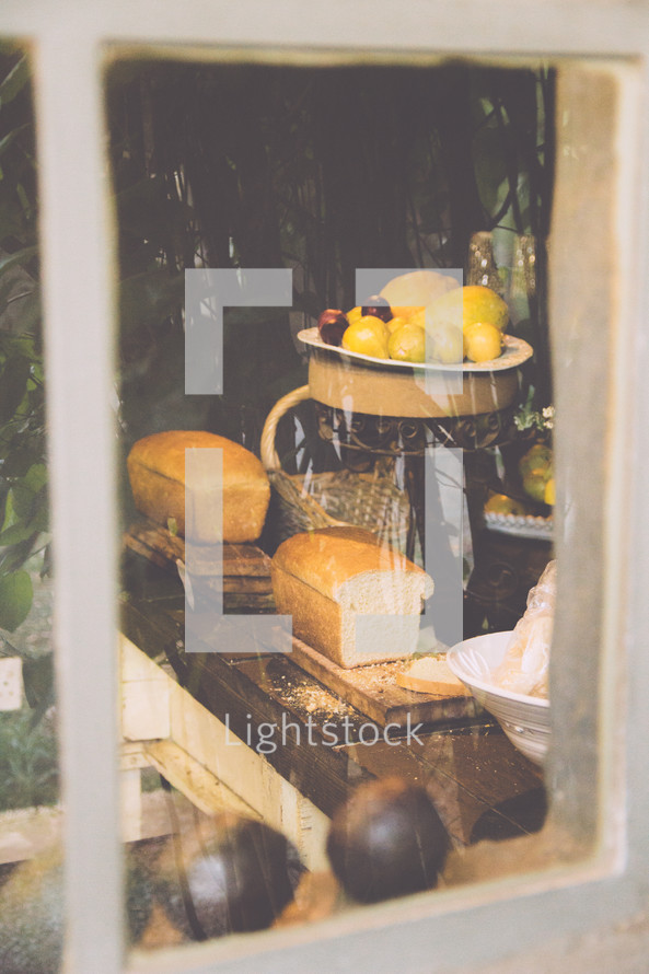 view into a kitchen through a window of lemons and bread 