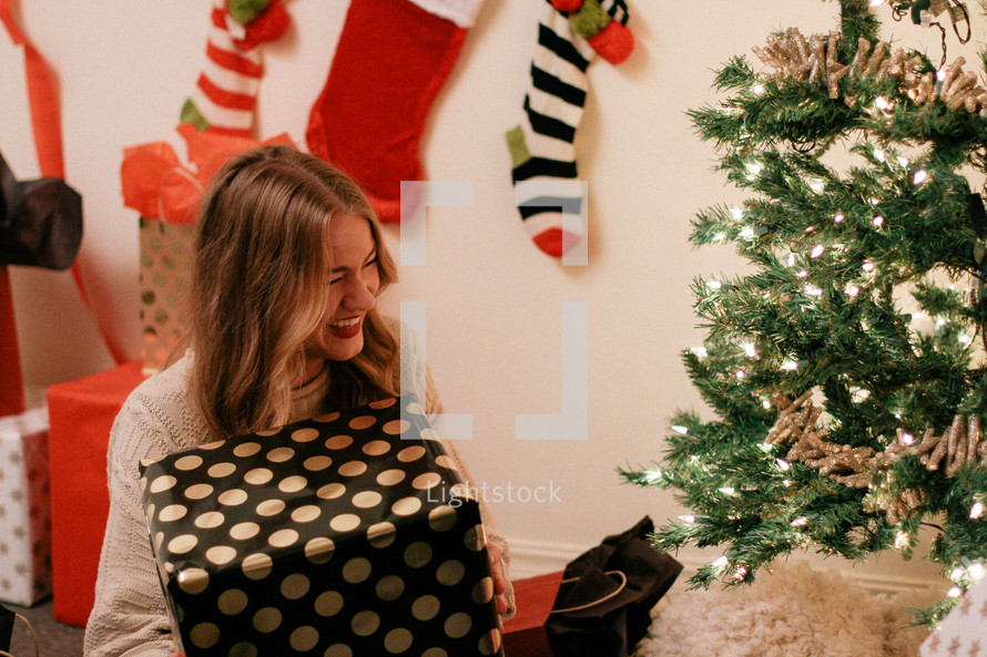 woman holding a large wrapped Christmas gift 