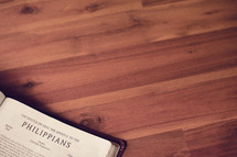 BIble on a wood floor opened to Philippians 