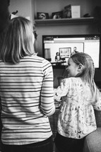 mother and daughter watching an online worship service at home 
